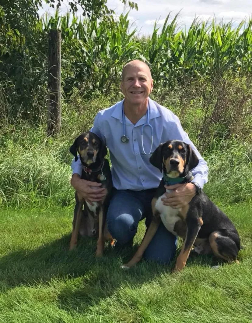 Dr. Gilligan's staff photo from North Lake Veterinary Clinic and his two dogs next to him.